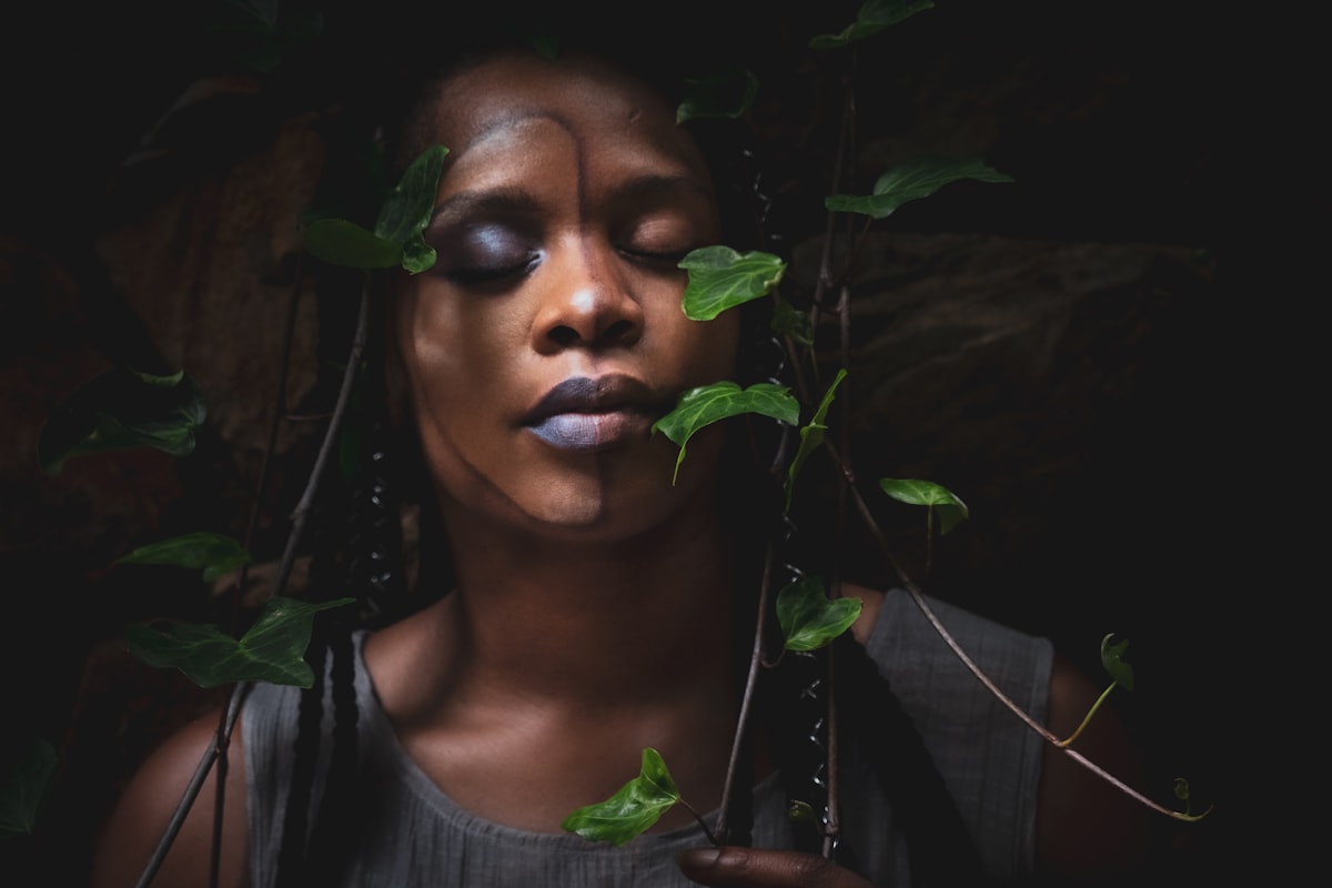 A portrait of a woman framed by trailing ivy.