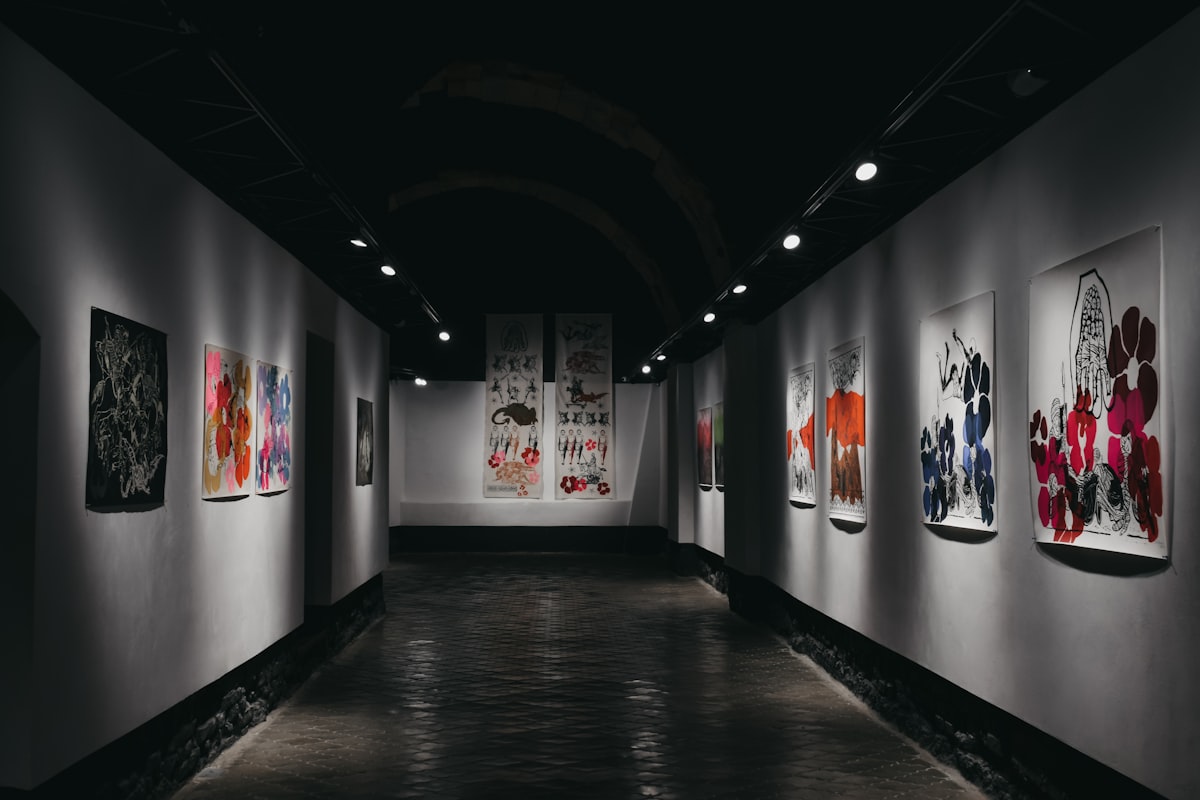 A vaulted gallery hung with colourful prints.